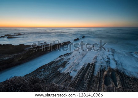 North America, USA, California.  Last light after sunset on rock formations with ocean at Montana de Oro State Park, CA