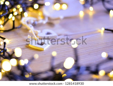White hearts and wooden background with a lights.  With space for text. Focus on heart, foreground and background are blurred. Chic, card.