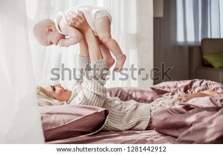 young beautiful blond mother taking rest with her baby