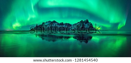 Aurora reflections on Stokksnes black beach with Vestrahorn mountains in center, Iceland Royalty-Free Stock Photo #1281454540