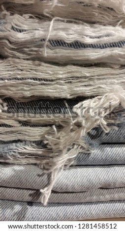 Cloth. Denim fabric. Torn denim fabric. Textile background from torn denim