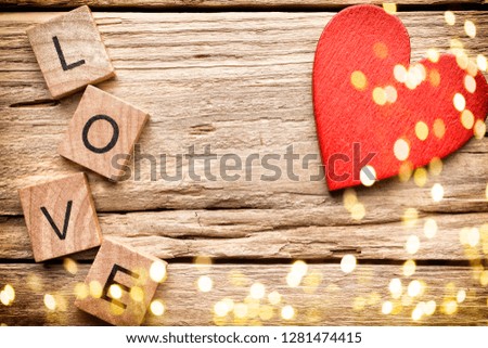 Red heart on old wooden background - Stock Image. I love you, cast out of wood kubik.