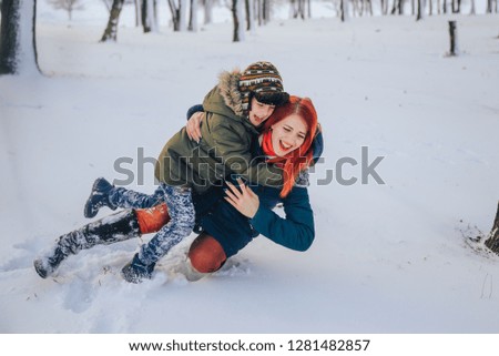 Mom and son int the winter forest