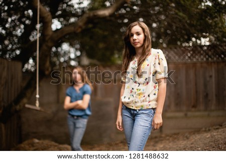 Two teenage girls in a backyard.