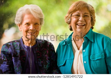Senior woman with an oxygen nose hose (cannula) and a mature women smile as they pose for a portrait together.