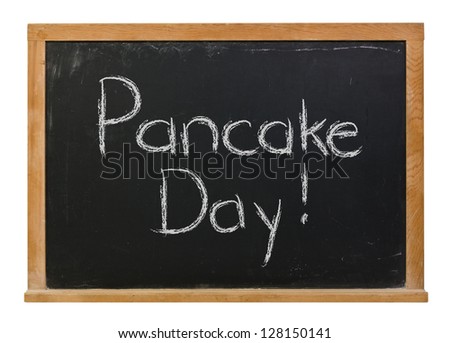 Pancake Day written in white chalk on a black chalkboard isolated on white