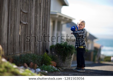 Portrait of a young boy playing outside with a toy football.