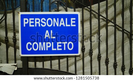 Sign with "complete personal" writing in Italian on the gate of a building site