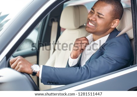 Young businessman driver sitting inside the car driving holding collar aside feeling hot uncomfortable side view in opened window close-up Royalty-Free Stock Photo #1281511447