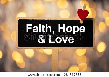 Faith Hope And Love blackboard with red heart against beautiful shiny background.