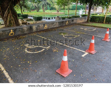Parking lot with painted yellow sign of wheelchair on asphalt, parking spaces for disabled visitors. Disabled parking spaces