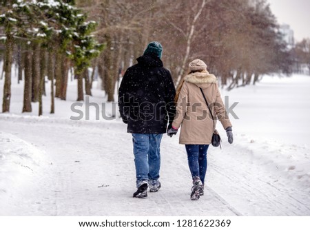 A guy and a girl walking in winter Park
