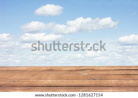 brown wooden table on a background of clouds, blank for advertising, designers, natural background