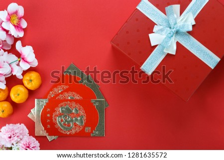 Chinese new year festival decoration with orange flower and packet in Red theme - Chinese characters mean happiness,  great luck, great profit
