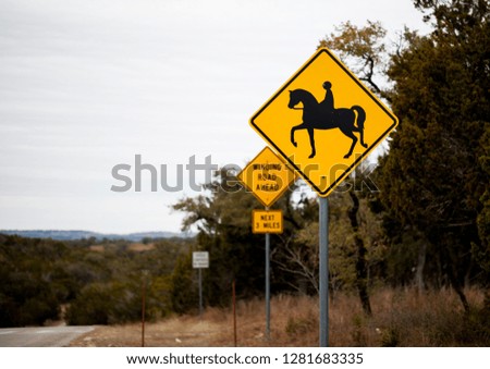 Yellow horse crossing sign at the beggining of a trail