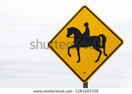 Yellow horse crossing sign at the beggining of a trail