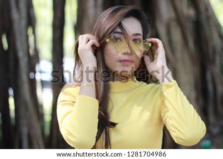 Face portrait of Asian lady with long hair. Yellow sunglasses. 