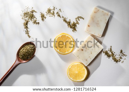 Flat lay of two handmade lemon tea bar soaps with a spoonful of tea leaves and lemon slices Royalty-Free Stock Photo #1281716524