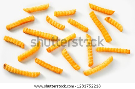 Scattered crinkle cut golden fried potato chips scattered on a white background in a flat lay still life Royalty-Free Stock Photo #1281752218