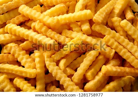 Full frame rippled french fries or chips in overhead view for advertising concept. Royalty-Free Stock Photo #1281758977