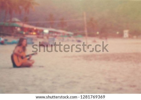 girl with guitar on beach, blurred photo