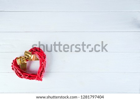 Wooden rustic red decorative heart hanging on white wooden background with space, flat lay. Valentine's background