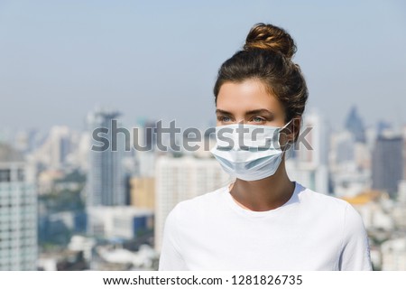 Woman wearing face mask because of Air pollution or virus epidemic in the city Royalty-Free Stock Photo #1281826735