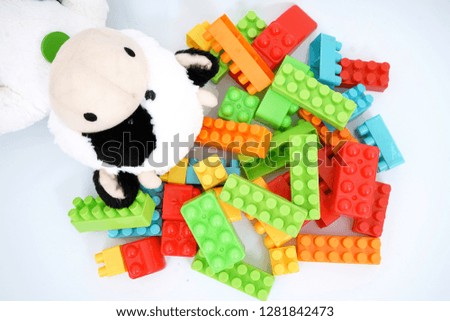 Plastic toy blocks and cow doll on a white background