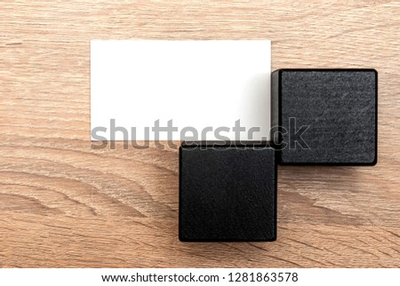 White blank business cards for text and logo on a wooden light table.