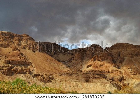 storm over mountain Masada in Judean desert, Israel. dark blue sky above the mountain next to dead sea