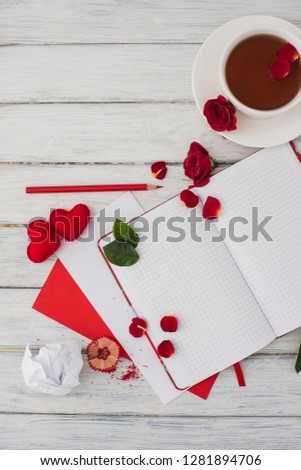 Valentines day. Notebook on a white wooden table with red hearts. Romantic morning on the day of lovers. Top view