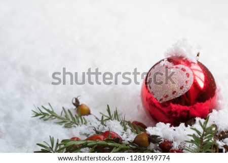 Merry Christmas - Christmas balls on the snow, winter bokeh background, red balls on the snow, rays of light