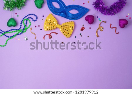Carnival or mardi gras background with carnival masks, beards and photo booth props. Top view from above