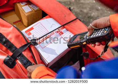 Young modern delivery man use barcode scanner on delivery work time.