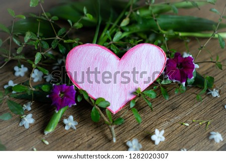 Pink paper heart and White flower on a wooden table