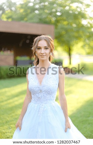 American pretty fiancee standing in park. oncapt of bridal hair do and wedding photo session on nature.