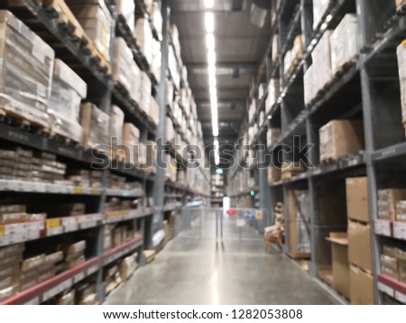 Blurred business background, Lt is a warehouse of a large-scale shopping center, Rows of shelves with boxes.