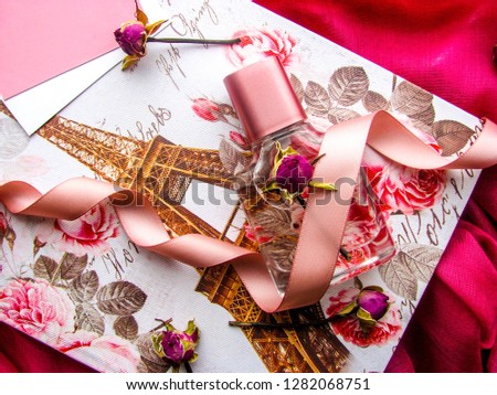 Romantic concept. gift box with the image of the Eiffel Tower, an envelope, a bottle of perfume and flowers.