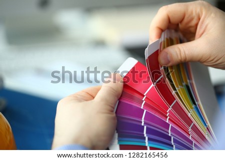 Employee refueling cartridge service holds magnifying glass in hand. Color print of pantone statistics offset organization gives customer an order products for distribution during promotion concept