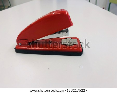 The red desktop staples on the white background table.