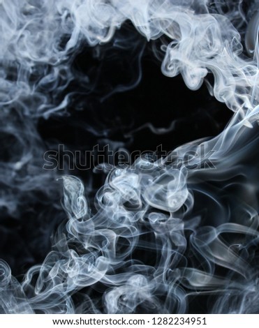 A thick blue twirling smoke pattern in front of a black background/drifting smoke overlay or texture design. 