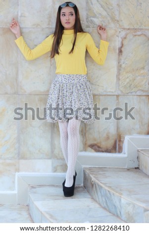 Cute young Asian women wearing yellow top and mini skirt. Cute fashion inspiration.