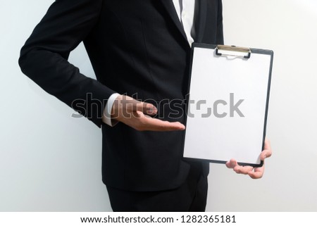young business man wearing a suit while holding sign board, clipping path, space for text