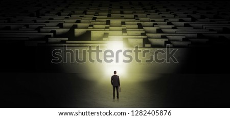Businessman getting ready to enter the dark labyrinth with illuminated door