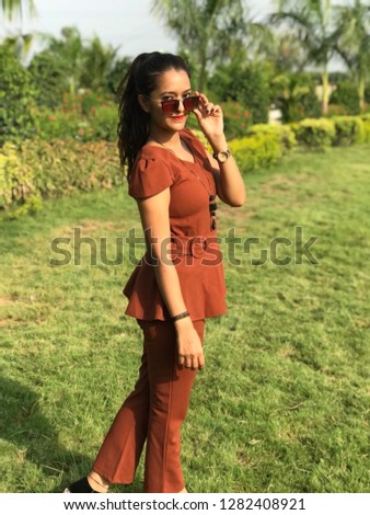 Beautiful Young girl smiling while  taking selfshot in garden.
 or selfy picture on digital photo camera or mobile phone in the garden
