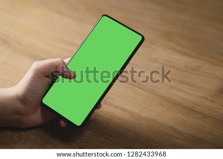 closeup shot of female teen hands with smartphone at the table