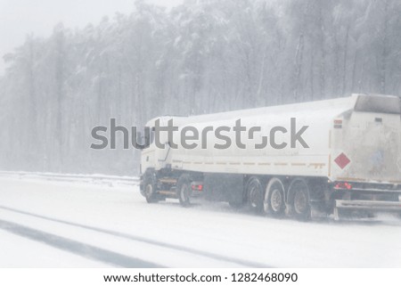 dangerous winter road conditions on a highway with oncoming traffic during heavy snowfall
