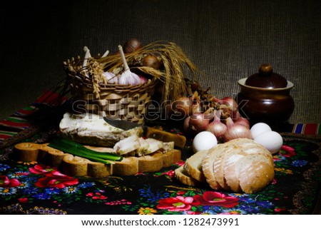 Traditional Russian cuisine. On a brown background, rustic dishes. Onions, garlic, bacon, egg, bread, milk. Close-up