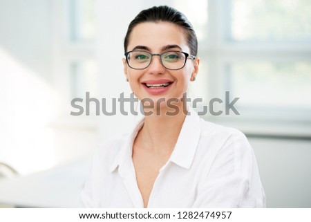 Portrait of a smiling young attractive business woman in an office