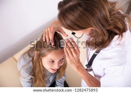 Close-up Of A Doctor Examining Girl's Hair With Comb
